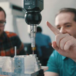 Two people look at a quality inspection machine