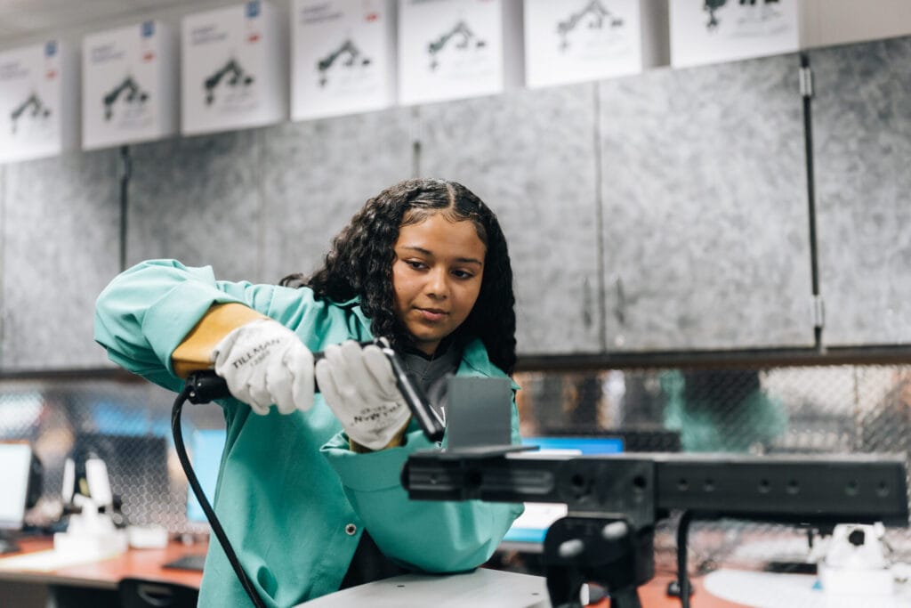 A female GO TEC middle school student uses a welding simulator. 